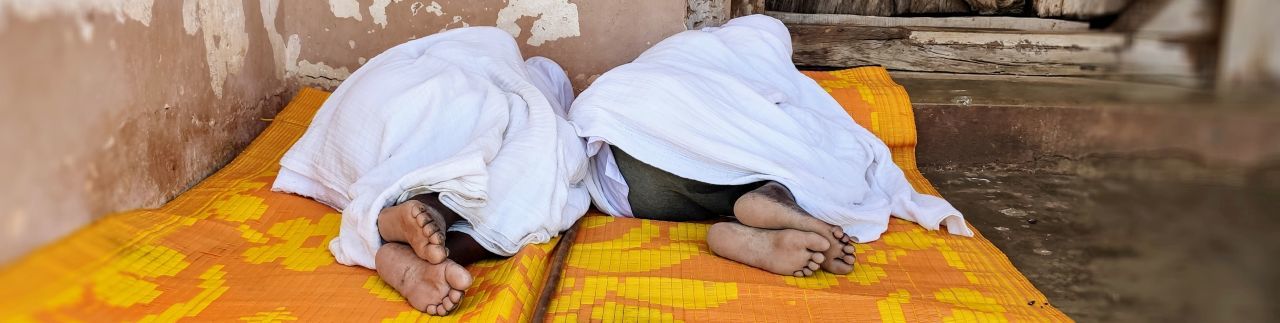 Zwei alte Pilger schlafen vor einer Felsenkirche in Tigray