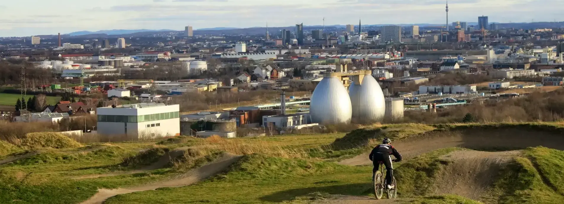 Mountainbike Fahrer auf dem Dusenberg mit der Skyline von Dortmund